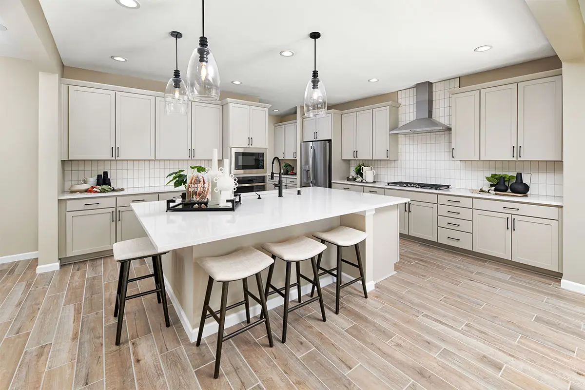 Kitchen with large island white countertops and cabinets and stainless-steel appliances