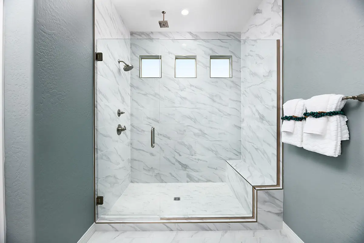 Walk-in shower with granite tile and grey walls