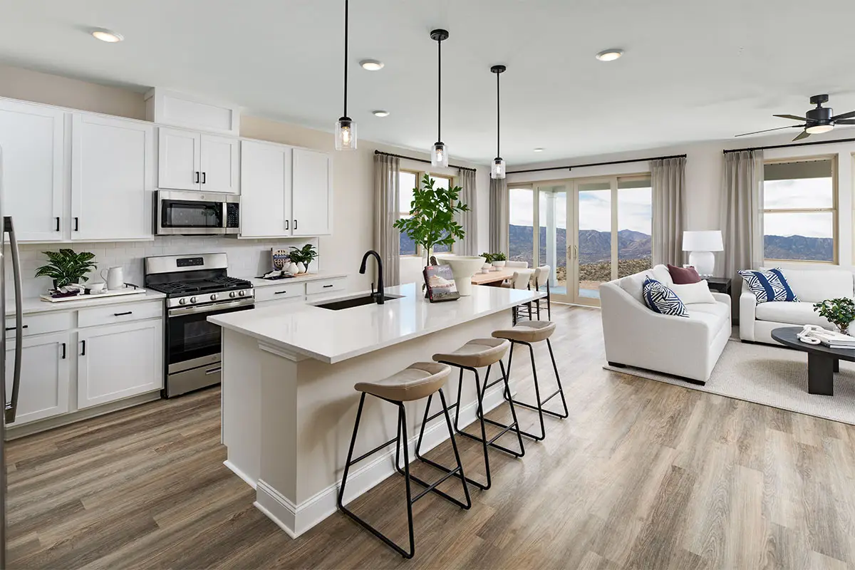 Kitchen with white cabinets and white countertops, wooden hardwood flooring